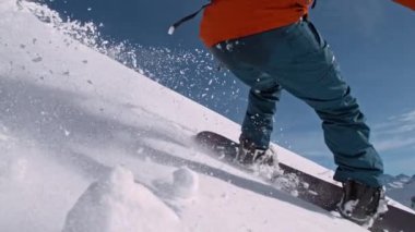 Piste Snowboardcusu 'nun orada. Süper Yavaş Hareket, 1000 fp. Güneşli bir günde Piste Yamacında, Avrupa Alp Dağları 'nda açık mavi gökyüzüyle snowboard yapmak, Avusturya.