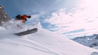Piste Snowboardcusu atlayışı. Süper Yavaş Hareket, 1000 fp. Güneşli bir günde Piste Yamacında, Avrupa Alp Dağları 'nda açık mavi gökyüzüyle snowboard yapmak, Avusturya.