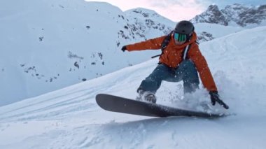 Piste Snowboardcusu 'nun orada. Süper Yavaş Hareket, 1000 fp. Avusturya 'nın Avrupa Alp Dağları' nda açık mavi gökyüzü ile güneşli bir günde Piste yamacında snowboard yapmak. Hız Rampası Efekti.