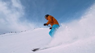 Piste kayakçı koşuyor. Süper Yavaş Hareket, 1000 fp. Avrupa Alp Dağları 'nda güneşli bir günde Piste yamacında açık mavi gökyüzüyle kayak yapmak. Hız Rampası Efekti.