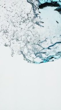 Süper Yavaş Uçan Su Sıçratma Hareketi, Mavi Arka plan 'da izole edilmiş. Yüksek Hız Sineması Kamerası 'nda çekildi, 1000fps. Dikey Görünüm Oranı.