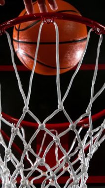 Basketbol topunun Basket 'e Vuruşunun Süper Yavaş Hareketi. Yüksek Hız Sineması Kamerası 'nda çekildi, 1000fps. Kamera hareket halinde. Dikey Görünüm Oranı.