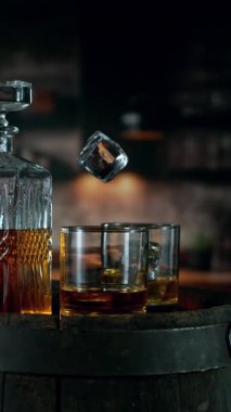 Süper Yavaş Buz Küpü Kamera Hareketi ile Viski Bardağına Düşüyor. High Speed Cinema Camera 'da çekildi, 1000 fps. Dikey Görünüm Oranı.