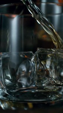 Viskiyi bardağa doldurmanın süper yavaş hareketi. High Speed Cinema Camera 'da çekildi, 1000 fps. Kamera hareket halinde. Makro çekim.