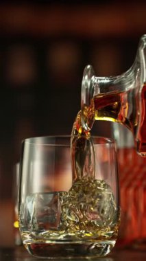 Viskiyi bardağa doldurmanın süper yavaş hareketi. High Speed Cinema Camera 'da çekildi, 1000 fps. Kamera Hareket Kontrol 'e yerleştirildi. Arkaplanda Bar, Odak Derinliği Düşük. Dikey Görünüm Oranı.