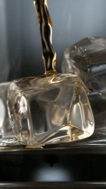 Viskiyi bardağa doldurmanın süper yavaş hareketi. High Speed Cinema Camera 'da çekildi, 1000 fps. Düşük Odaklanma Derinliği. Dikey Görünüm Oranı.