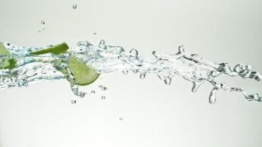 Uçan kireç dilimlerinin Su Sıçratmada Süper Yavaş Hareketi, Beyaz Arkaplan. Yüksek Hız Sinema Kamerası, 1000 fp..