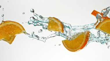 Süper Yavaş Uçan Portakal Dilimleri Su Sıçratır, Beyaz Arkaplan. Yüksek Hız Sinema Kamerası, 1000 fp..