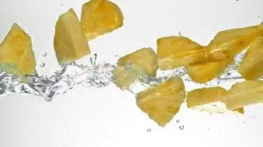 Su Sıçratan Ananas Dilimlerinin Süper Yavaş Hareketi, Beyaz Arkaplan. High Speed Cinema Camera 'da çekildi, 1000 fps. Hız Rampası Efekti.