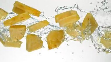Su Sıçratan Ananas Dilimlerinin Süper Yavaş Hareketi, Beyaz Arkaplan. High Speed Cinema Camera 'da çekildi, 1000 fps. Hız Rampası Efekti.