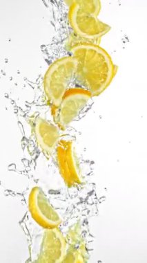 Uçan kireç dilimlerinin Su Sıçratmada Süper Yavaş Hareketi, Beyaz Arkaplan. High Speed Cinema Camera 'da çekildi, 1000 fps. Dikey Görünüm Oranı.