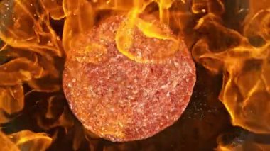 Hamburger Kıymalı Çiğ Biftek Kızartma Tavasına Alevlerle Düşüyor. Yüksek Görüş açısı. High Speed Cinema Camera 'da çekildi, 1000 fps. Süper Yavaş Hareket.