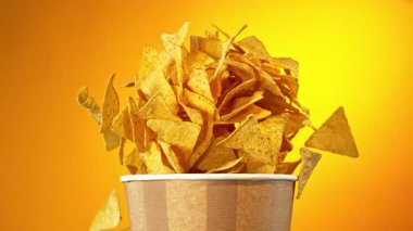 Flying Fried Tortilla Chips 'in Kova' dan Süper Yavaş Hareketi. Renkli Arka plan 'da izole edilmiş. High Speed Cinema Camera 'da çekildi, 1000 fps. Hız Rampası Efekti.