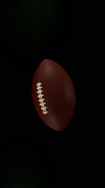 Düşen Amerikan Futbol Topunun Süper Yavaş Hareketi ve Renkli Pudra Patlaması, Top View. Yüksek Hız Sineması Kamerası 'nda çekildi, 1000fps. Dikey Görünüm Oranı.