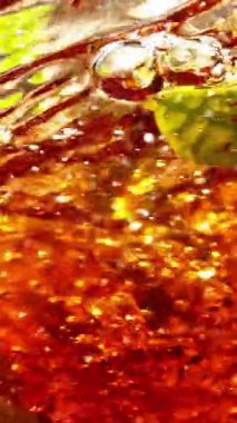 Kasırga şeklinde suya çay dökmek çok yavaş bir hareket. İçeride taze yeşil yapraklar var. Yüksek hızlı sinema kamerasıyla çekildi, 1000fps. Dikey görünüm oranı.