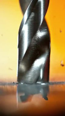 Alüminyum boruyu delen matkap ucu çok yavaş hareket ediyor. Yüksek hızlı sinema kamerası, 1000 fps. Dikey görünüm oranı.