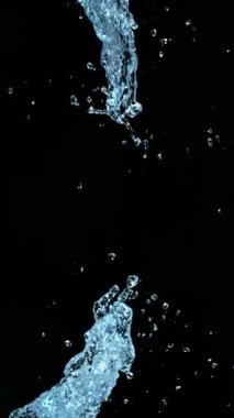 Uçan Su Sıçratma Süper Yavaş Hareketi, Kara Arkaplan. Yüksek Hız Sineması Kamerası 'nda çekildi, 1000fps. Dikey Görünüm Oranı.