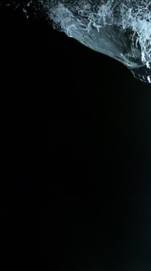 Uçan Su Sıçratma Süper Yavaş Hareketi, Kara Arkaplan. Yüksek Hız Sineması Kamerası 'nda çekildi, 1000fps. Dikey Görünüm Oranı.