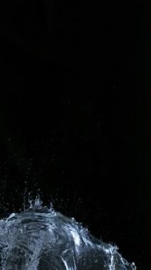 Uçan Su Sıçratma Süper Yavaş Hareketi, Kara Arkaplan. Yüksek Hız Sineması Kamerası 'nda çekildi, 1000fps. Dikey Görünüm Oranı.