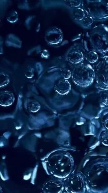 Köpüren Mavi Suyun Süper Yavaş Hareketi. Ekstrem Makro Vuruş, Soyut Doku. High Speed Cinema Camera 'da çekildi, 1000 fps. Dikey Görünüm Oranı.
