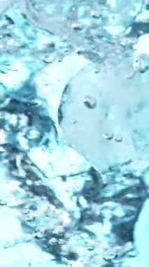 Suda dönen buz küplerinin süper yavaş hareketi. Yüksek hızlı sinema kamerası, 1000 fps. Sualtı bileşimi. Dikey görünüm oranı.