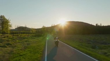 Dağ manzarasında motosiklet sürücüsü. Sunset Light ile Güzel Yaşam Tarzı Panoramik Manzarası. Motosiklette yaşam tarzı turu.