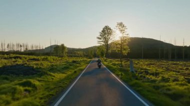 Dağ manzarasında motosiklet sürücüsü. Sunset Light ile Güzel Yaşam Tarzı Panoramik Manzarası. Motosiklette yaşam tarzı turu.