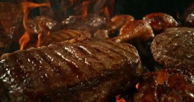 Izgarada ızgara et ve ateş karışımı. Barbekü ve Lezzetli Taze Yemek. Slow Motion, High Speed Cinema Camera 'da çekildi. Hareketli Kamera.