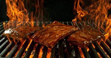 Alevli mangal ızgarasında farklı türde et. Kara Arkaplanda İzole Edilmiş.