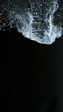 Uçan Su Sıçratma Süper Yavaş Hareketi, Kara Arkaplan. Yüksek Hız Sineması Kamerası 'nda çekildi, 1000fps. Dikey Görünüm Oranı.