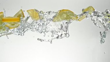 Uçan Limon Dilimlerinin Süper Yavaş Hareketi Su Sıçratmaları, Beyaz Arkaplan. Yüksek Hız Sinema Kamerası, 1000 fp..