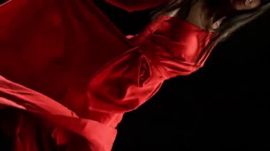 Yakut kırmızısı elbiseli çarpıcı siyah saçlı kadın ve yüksek topuklu zarif siyah arka plan pozu, Süper Yavaş Çekimde Yakalandı. Kamera Döndürme. Hız Rampası Efekti.