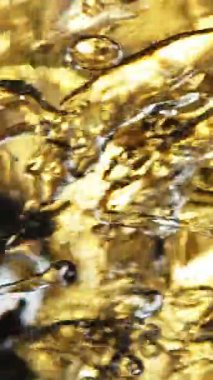 Su sıçratma yağının süper yavaş akışı. Makro soyut çekim. Yüksek hızlı sinema kamerasıyla çekildi, 1000fps. Dikey görünüm oranı.