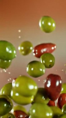 Uçan ve Dönen Yeşil ve Siyah Zeytinlerin Süper Yavaş Hareketi. High Speed Cinema Camera 'da çekildi, 1000 fps. Dikey Görünüm Oranı.