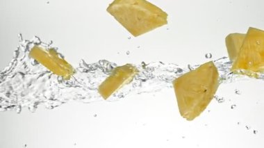 Uçan Çam Elması Dilimlerinin Su Sıçratmada Süper Yavaş Hareketi, Beyaz Arkaplan. Yüksek Hız Sinema Kamerası, 1000 fp..