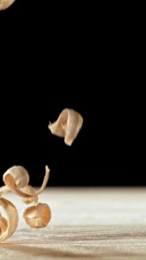 Talaş taneciklerinin düşüşünün süper yavaş çekimi. Yüksek hızlı sinema kamerası, 1000 fps. Siyah arka plan. Dikey görünüm oranı.