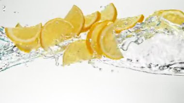 Uçan Limon Dilimlerinin Süper Yavaş Hareketi Su Sıçratmaları, Beyaz Arkaplan. High Speed Cinema Camera 'da çekildi, 1000 fps. Hız Rampası Efekti.