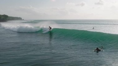 Ağır çekim sörfçü Bali 'de güçlü bir okyanus dalgasına biniyor. Dinamik Hareket Sörf, Macera, Seyahat ve Yaşam Tarzı Konseptleri için Mükemmel. Sinematik ve Enerjik Titreşimler.