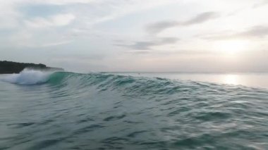 Yavaş Hareketli Okyanus Dalgası Bali 'de kıyıya çarpıyor. Sörf, seyahat ve doğa kavramları için mükemmel. Dinamik ve Sinema Sahil Enerjisi.
