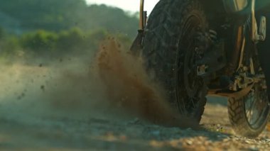 Bir off-road motosikletinin arka tekerini döndürüp havaya çamur atmasının süper yavaş çekimi. Işıklandırma, Hareket ve Patlayıcı Arazi Çarpışması 'na 300 fp kala ele geçirildi. Hız Rampası Efekti