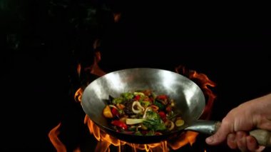 Sebze ve Etli Uçan Asya Yemeklerinin Süper Yavaş Hareketi. Yüksek Hız Sinema Kamerası 'nda çekildi, 600 fps. Kara Arkaplanda İzole Edilmiş, Alevler Yanar.