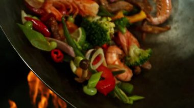 Sebze ve Etli Uçan Asya Yemeklerinin Süper Yavaş Hareketi. Yüksek Hız Sinema Kamerası 'nda çekildi, 600 fps. Kara Arkaplanda İzole Edilmiş, Alevler Yanar.