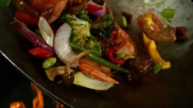 Sebze ve Etli Uçan Asya Yemeklerinin Süper Yavaş Hareketi. Yüksek Hız Sinema Kamerası 'nda çekildi, 600 fps. Kara Arkaplanda İzole Edilmiş, Alevler Yanar.