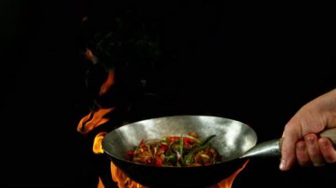 Sebze ve Etli Uçan Asya Yemeklerinin Süper Yavaş Hareketi. Yüksek Hız Sinema Kamerası 'nda çekildi, 600 fps. Kara Arkaplanda İzole Edilmiş, Alevler Yanar.