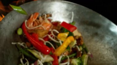 Sebze ve Etli Uçan Asya Yemeklerinin Süper Yavaş Hareketi. Yüksek Hız Sinema Kamerası 'nda çekildi, 600 fps. Kara Arkaplanda İzole Edilmiş, Alevler Yanar.