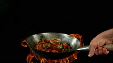 Sebze ve Etli Uçan Asya Yemeklerinin Süper Yavaş Hareketi. Yüksek Hız Sinema Kamerası 'nda çekildi, 600 fps. Kara Arkaplanda İzole Edilmiş, Alevler Yanar.