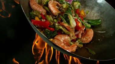 Sebze ve Etli Uçan Asya Yemeklerinin Süper Yavaş Hareketi. Yüksek Hız Sinema Kamerası 'nda çekildi, 600 fps. Kara Arkaplanda İzole Edilmiş, Alevler Yanar.