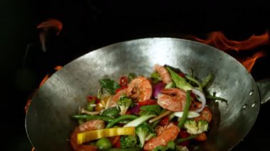 Sebze ve Etli Uçan Asya Yemeklerinin Süper Yavaş Hareketi. Yüksek Hız Sinema Kamerası 'nda çekildi, 600 fps. Kara Arkaplanda İzole Edilmiş, Alevler Yanar.