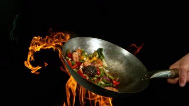 Sebze ve Etli Uçan Asya Yemeklerinin Süper Yavaş Hareketi. Yüksek Hız Sinema Kamerası 'nda çekildi, 600 fps. Kara Arkaplanda İzole Edilmiş, Alevler Yanar.