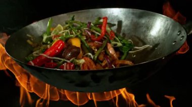 Sebze ve Etli Uçan Asya Yemeklerinin Süper Yavaş Hareketi. Yüksek Hız Sinema Kamerası 'nda çekildi, 600 fps. Kara Arkaplanda İzole Edilmiş, Alevler Yanar.